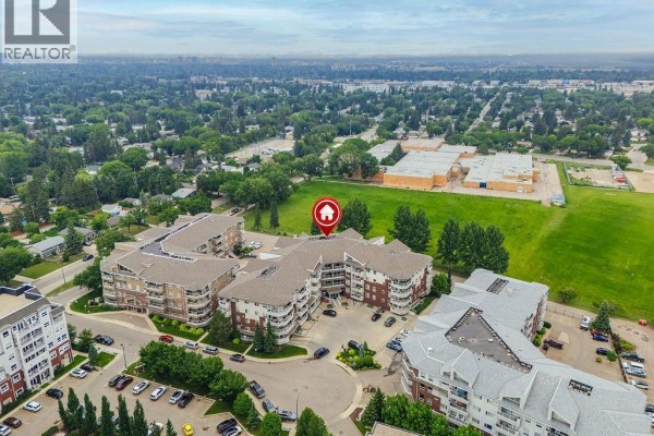 Aerial view showing the apartment building's location relative to a school. - 113 106 Armistice Way, Saskatoon