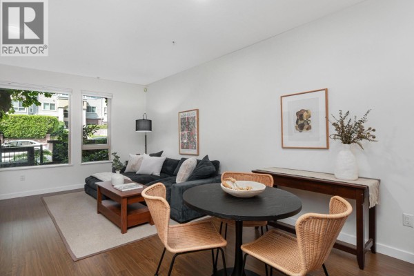 Dining area with a round table and chairs, adjacent to living space. - 113 119 W 22nd Street, North Vancouver
