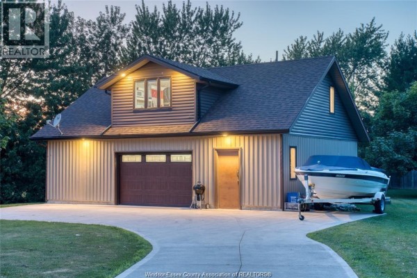 Daylight view of a detached garage with a boat on a trailer. - 113 Beach Court, Stoney Point