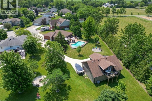 Backyard with concrete patio, adirondack chairs, swing set, and detached garage. - 113 Beach Court, Stoney Point