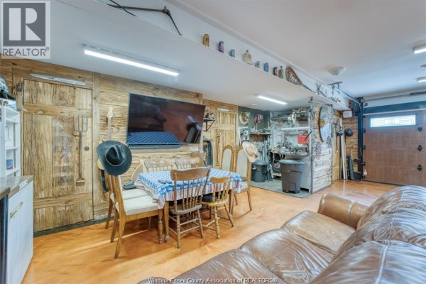 Living area with TV, dining set, leather sofa, and workbench - 113 Beach Court Stoney Point