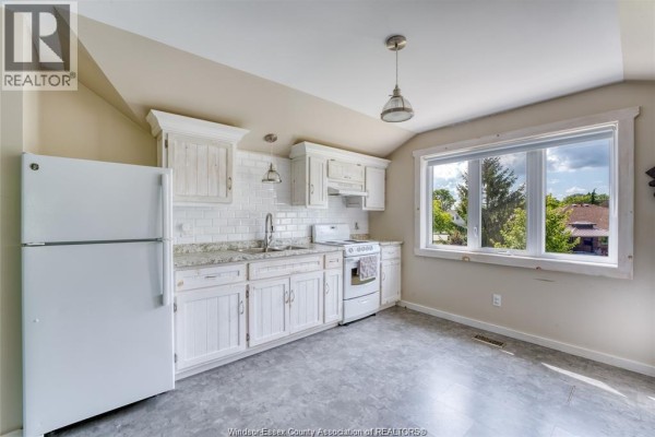 Kitchen with white cabinets, granite countertops, subway tile backsplash, and a large window - 113 Beach Court Stoney Point