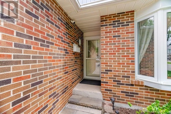 Side view of a townhouse complex showing multiple units with brick and siding exteriors. - 113 Fanshawe Drive, Brampton