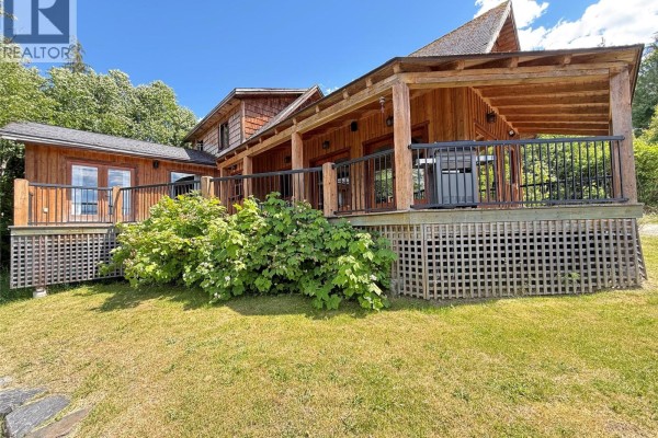 Wooden dock on Kootenay Lake with forested mountains and blue sky. - 113 Kootenay Lake Road, Procter