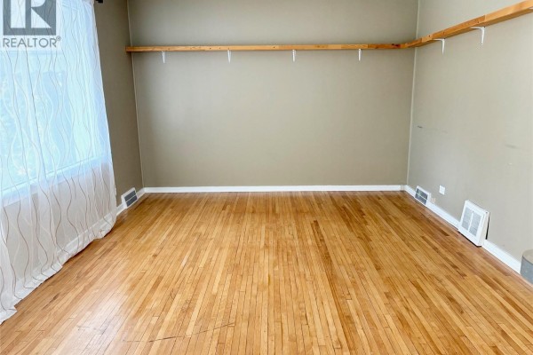 Compact kitchen with white cabinets, green backsplash, and appliances - 113 Laurier Avenue, Yorkton