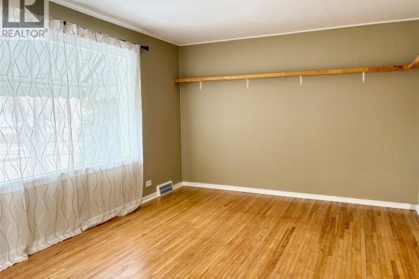 L-shaped kitchen layout featuring white cabinetry and a dining area - 113 Laurier Avenue, Yorkton