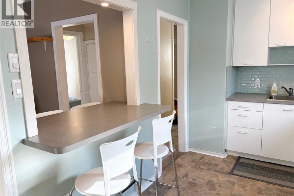 Bright kitchen with window, green tiles, and modern appliances - 113 Laurier Avenue, Yorkton