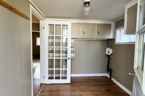 Interior room with wood floors, beige walls, glass-paned doors, and overhead cabinets. - 113 Midland Row, Pasadena