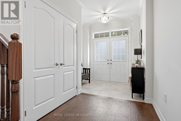 Interior foyer with double white doors, dark wood flooring, and tiled entryway. - 113 Taylor Avenue, Guelph/eramosa