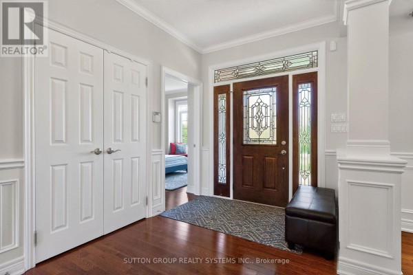 Entryway with a stained glass front door, double closet, bench, and wood flooring. - 11310 Taylor Court, Milton