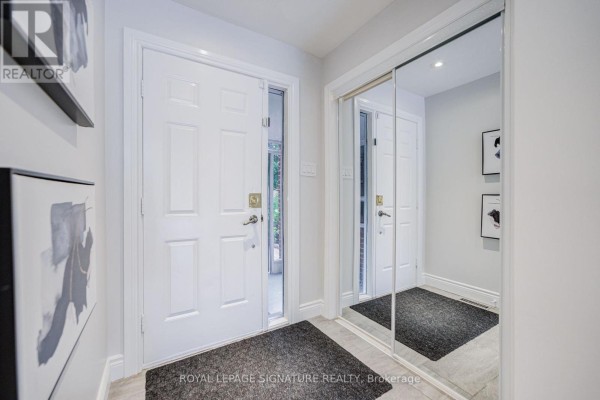 Interior entryway with white double doors, mirrored closet, and artwork on the wall. - 1132 Cedarcroft Crescent, Pickering