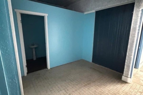 Interior room with a doorway leading to a small room with a pedestal sink. - 1132 Fifth Street, Estevan