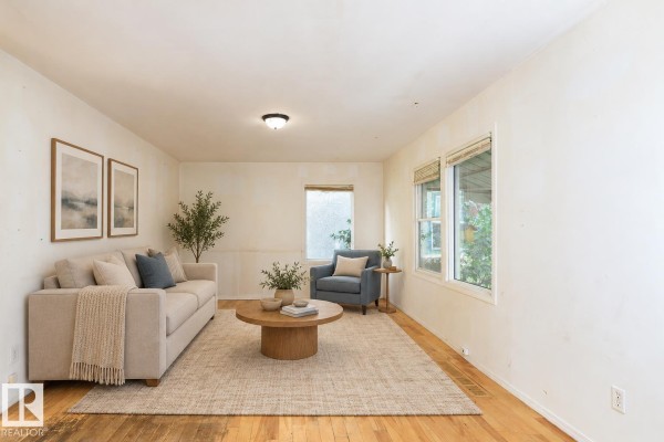 Virtual staged living room with beige sofa, blue armchair, coffee table, and rug. - 11321 89 St Nw, Edmonton