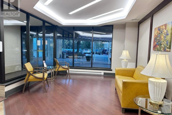 Lobby seating area with two yellow chairs, a sofa, and glass tables. - 1133 - 25 Bamburgh Circle, Toronto