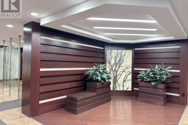 Lobby with wood accents, built-in seating, potted plants, and artwork. - 1133 - 25 Bamburgh Circle, Toronto