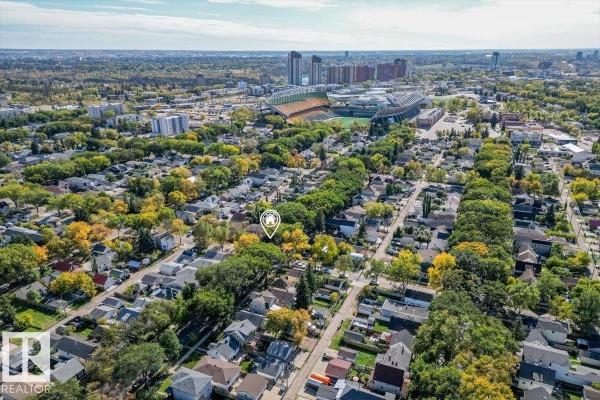 Aerial view of Edmonton neighbourhood with tree-lined streets and distant skyscrapers. - 11347 89 St Nw, Edmonton