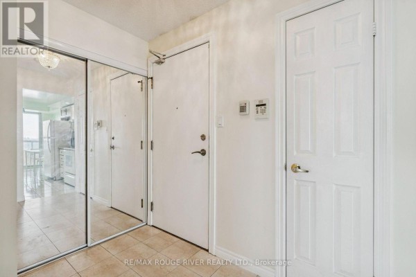Open living area with hardwood floors, bay windows, and a view into the adjacent room. - 1136 - 125 Omni Drive, Toronto