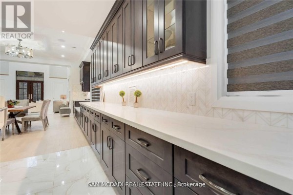 Kitchen with dark wood cabinets, quartz countertops, geometric tile backsplash - 1138 Garden Road Mississauga