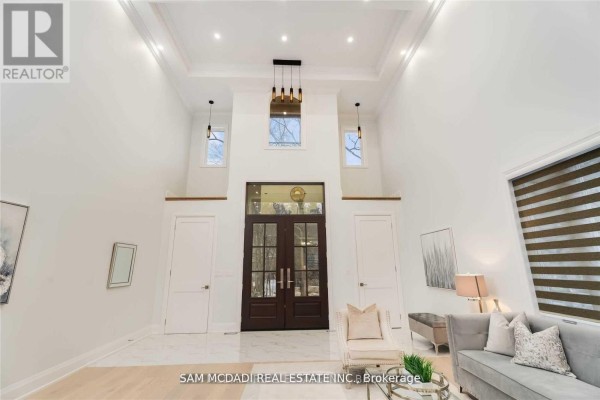 Grand entryway with vaulted ceiling, chandelier, pendant lights, and double doors - 1138 Garden Road Mississauga