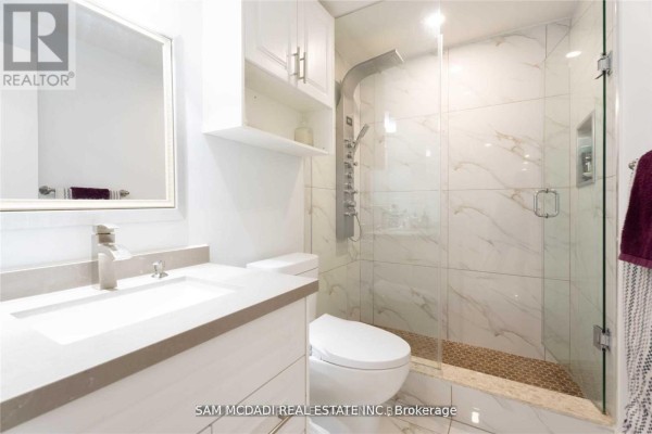Modern bathroom with walk-in shower, vanity, and marble tiles - 1138 Garden Road Mississauga
