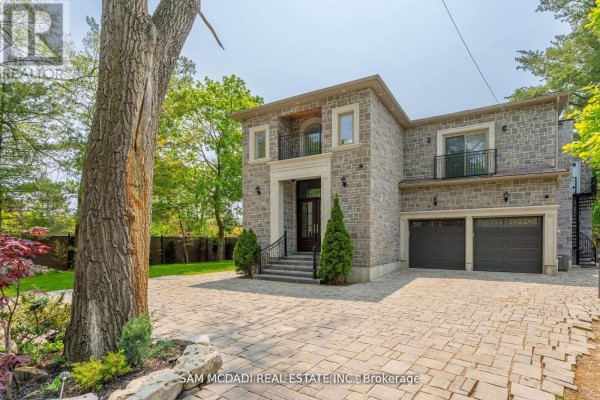 Stone house with double garage, balcony, paved driveway, and mature tree - 1138 Garden Road Mississauga