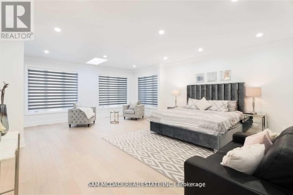 Modern bedroom with skylight, velvet headboard, and seating area - 1138 Garden Road Mississauga