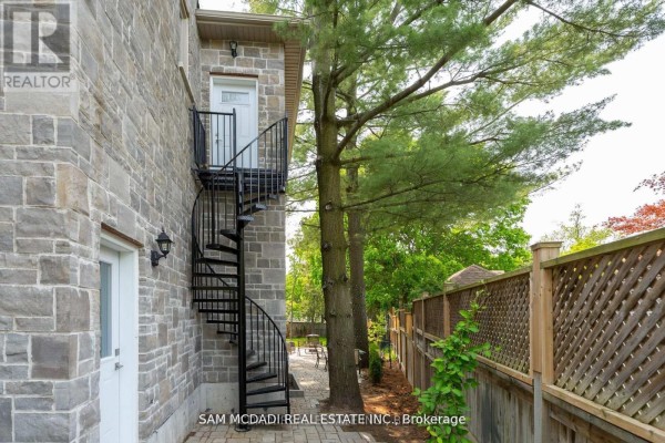 Stone house exterior with spiral staircase and lattice fence - 1138 Garden Road Mississauga