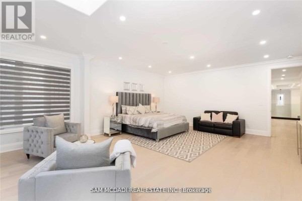 Spacious bedroom with king bed, leather sofa, and tufted chairs - 1138 Garden Road Mississauga