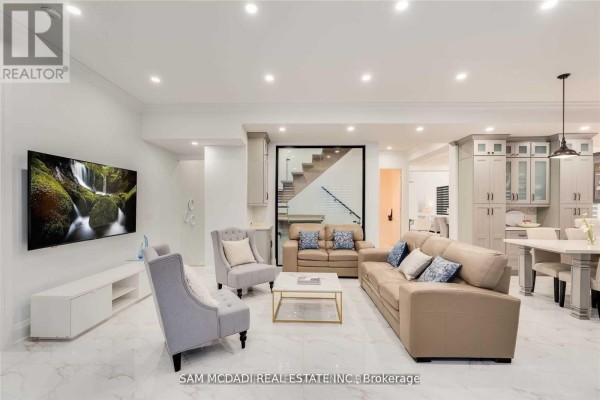 Living room with sofas, armchairs, and marble floors, adjacent to kitchen and staircase - 1138 Garden Road Mississauga