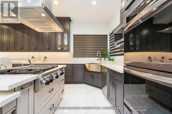 Modern kitchen with gas range, double oven, farmhouse sink, and island - 1138 Garden Road Mississauga