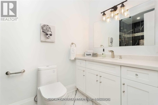 Modern bathroom with vanity, marble floor, and artwork - 1138 Garden Road Mississauga