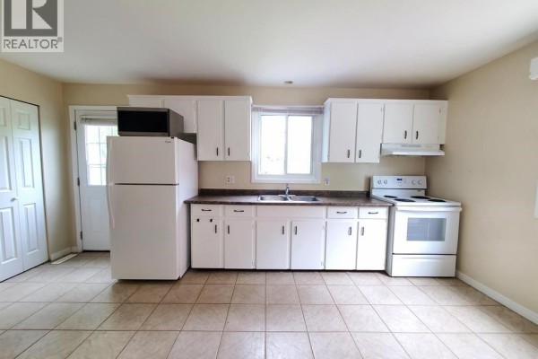 Kitchen with white cabinets, white appliances, beige walls, and beige tiled flooring. - 114 Lillian Drive Unit# B, Waterloo