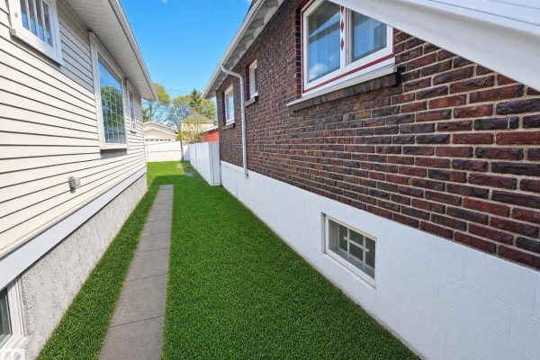 Sunroom with large windows covered by lace curtains, a patterned rug, and a tiled shelf. - 11405 97 St Nw, Edmonton