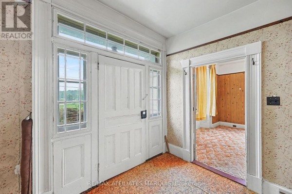 Entrance foyer with a white double door, sidelight windows, and textured wallpaper. - 11422 7th Line Road, Elizabethtown Kitley