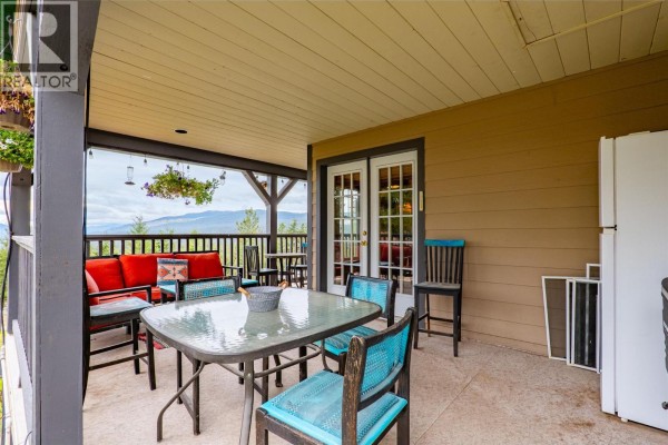 Covered patio area with outdoor furniture, a table, chairs, and a scenic view of the valley. - 11460 Hwy 97c Highway, Merritt