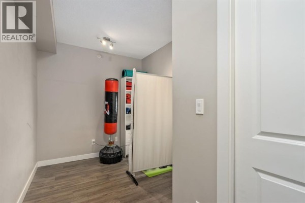 Spare room with a punching bag, yoga mats, and storage shelves. - 115, 10 Kincora Glen Park Nw, Calgary