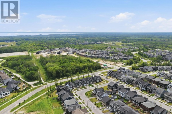 Aerial view of a large suburban development with roads, houses, and distant treed areas. - 115 Black Willow Crescent, Blue Mountains