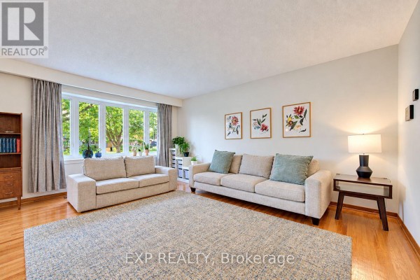 Interior entryway with a glass front door, wood closet, and view into a living room. - 115 Chopin Drive, Kitchener
