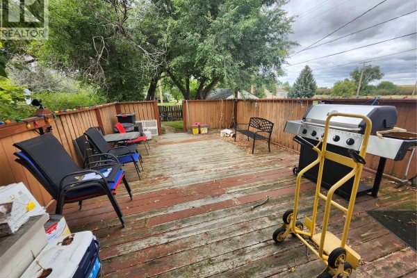 Wooden deck with chairs, a barbecue, a bench, and garden tools scattered around. - 115 Halyard Street, Pennant