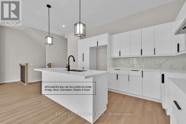 Modern kitchen with white cabinets, black hardware, marble backsplash, and a large island. - 115 Ivy Crescent, Thorold