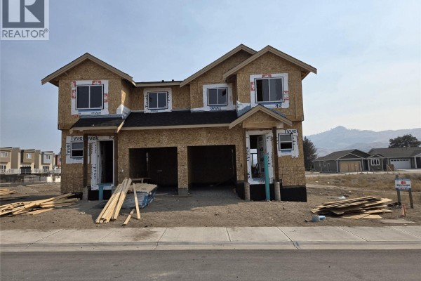 Exterior of duplex under construction with plywood sheathing, framing, and unfinished garages. - 115 Mallard Way Unit# 102, Osoyoos