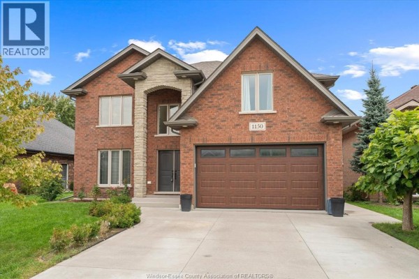 Front view of a large brick house with a two-car garage and neatly landscaped lawn. - 1150 Jillian Court, Lakeshore