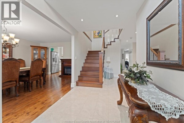 Interior foyer with a staircase, wood floors, a dining room area, and a large mirror. - 1150 Jillian Court, Lakeshore