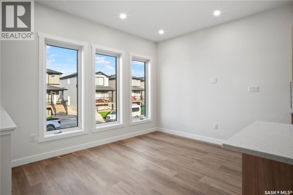 Dining area with three large windows overlooking the street. - 1150 Poley Street N, Regina