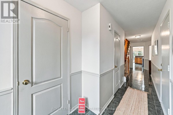 Interior hallway with wood floors, white railings, and view of dining room. - 1152 Westview Terrace, Oakville