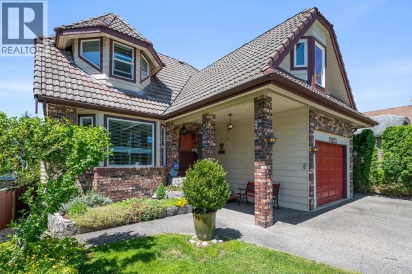 Side view of the house featuring a tiled roof and landscaped garden. - 11523 Bonson Road, Pitt Meadows