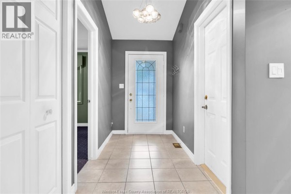 Tiled entryway with grey walls, a glass door, and white doors on either side. - 11568 Aldridge, Windsor