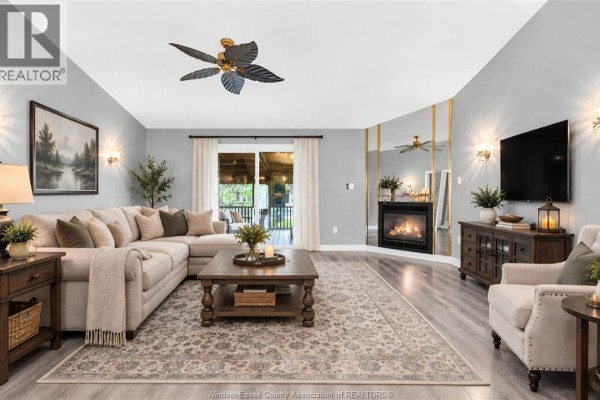 Living room featuring a sectional sofa, fireplace, large rug, and television. - 11568 Aldridge, Windsor