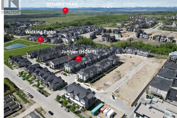 Row of townhouses with garages and balconies, snow-covered street - 116, 2231 81st Street Sw, Calgary