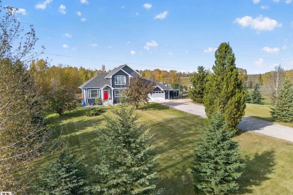 Large blue house with red front door and attached garage on a sunny day. - #116 53319 Rge Road 14, Rural Parkland County